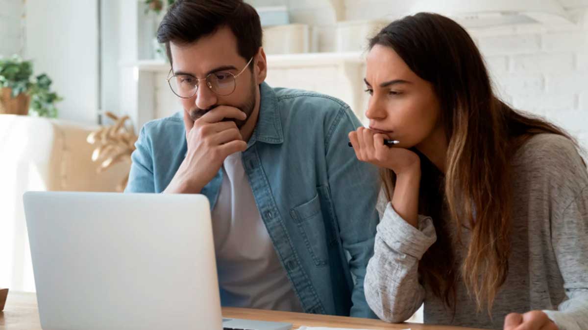 Pareja joven planificando la jubilación frente al ordenador