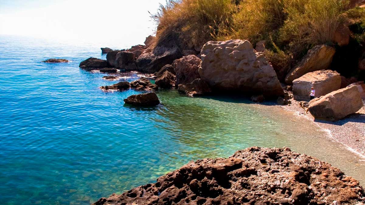 Cala virgen en la costa de Málaga entre Nerja y Maro con aguas cristalinas y rocas