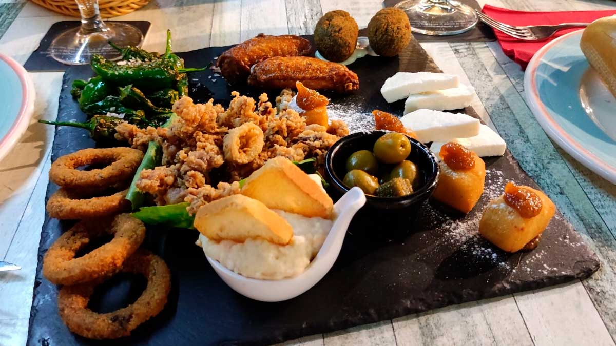 Tapas de Granada variadas en una tabla, ejemplo de tradición gastronómica local