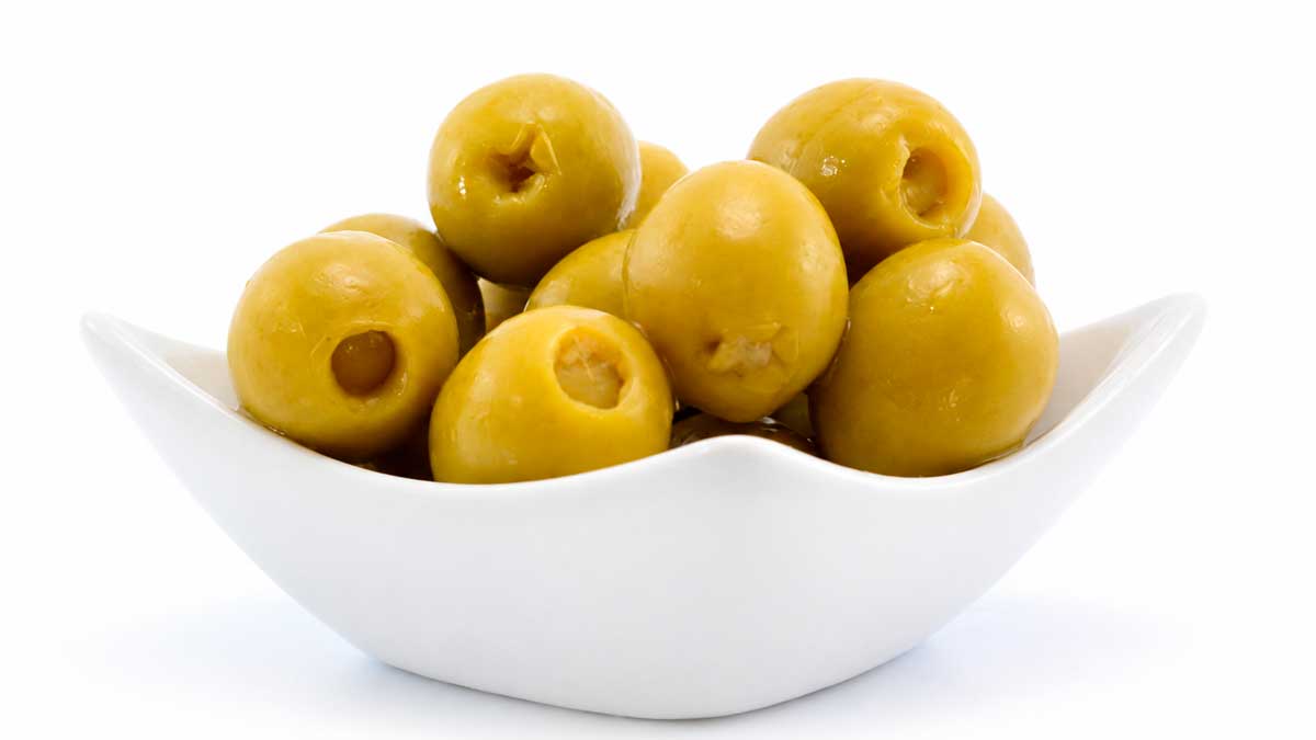 Frascos de aceitunas rellenas durante el llenado con salmuera en un ensayo del Instituto de la Grasa de Sevilla