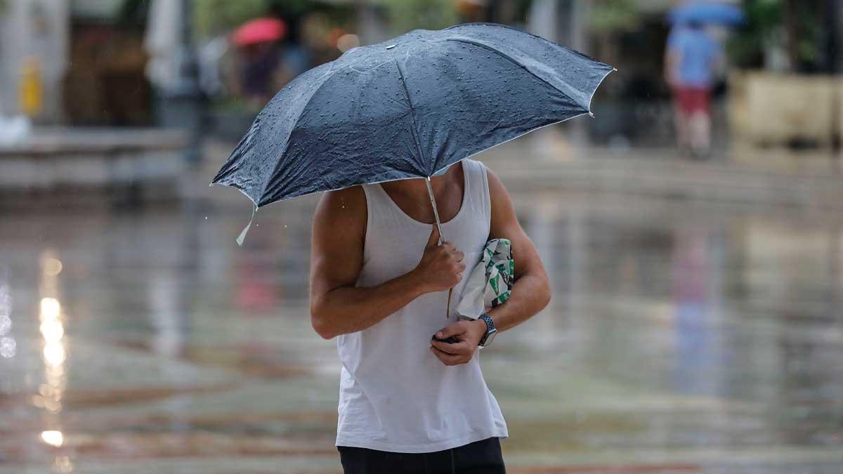 Persona con paraguas bajo la lluvia durante ola de calor en Andalucía