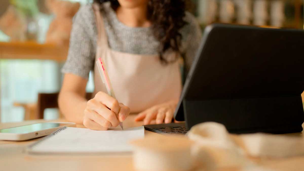 Persona autónoma en Andalucía trabajando con portátil y tomando notas sobre ayudas de hasta 6.500 euros