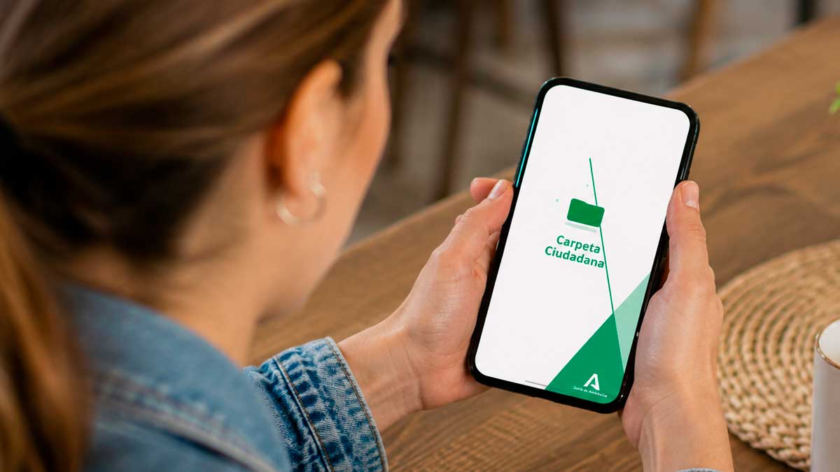 Mujer usando la app Carpeta Ciudadana andaluza en su móvil para gestionar trámites digitales