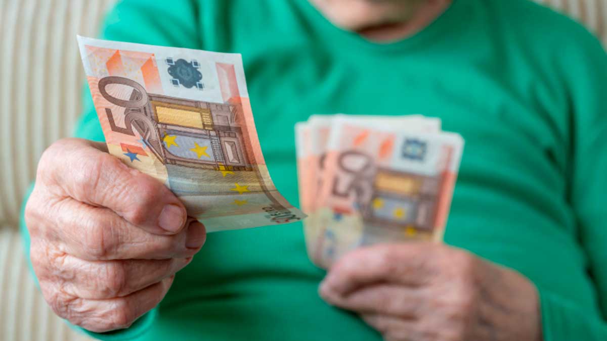 Pensionista no contributivo contando billetes de 50 euros para el complemento para el alquiler