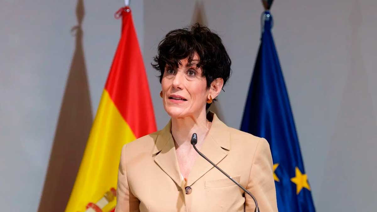 La ministra de Seguridad Social explica el complemento por mínimos en 2026 ante banderas de España y la UE