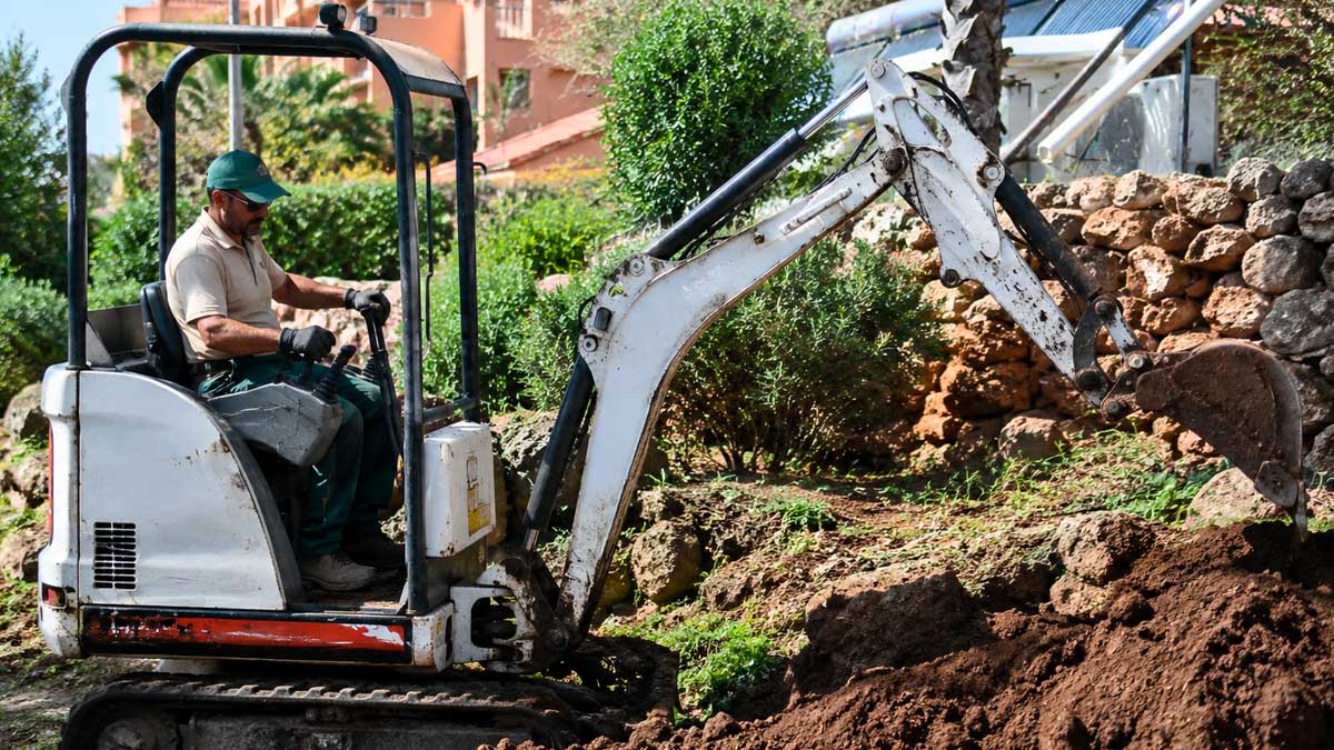 Trabajador operando maquinaria pesada en Málaga tras despido por baja