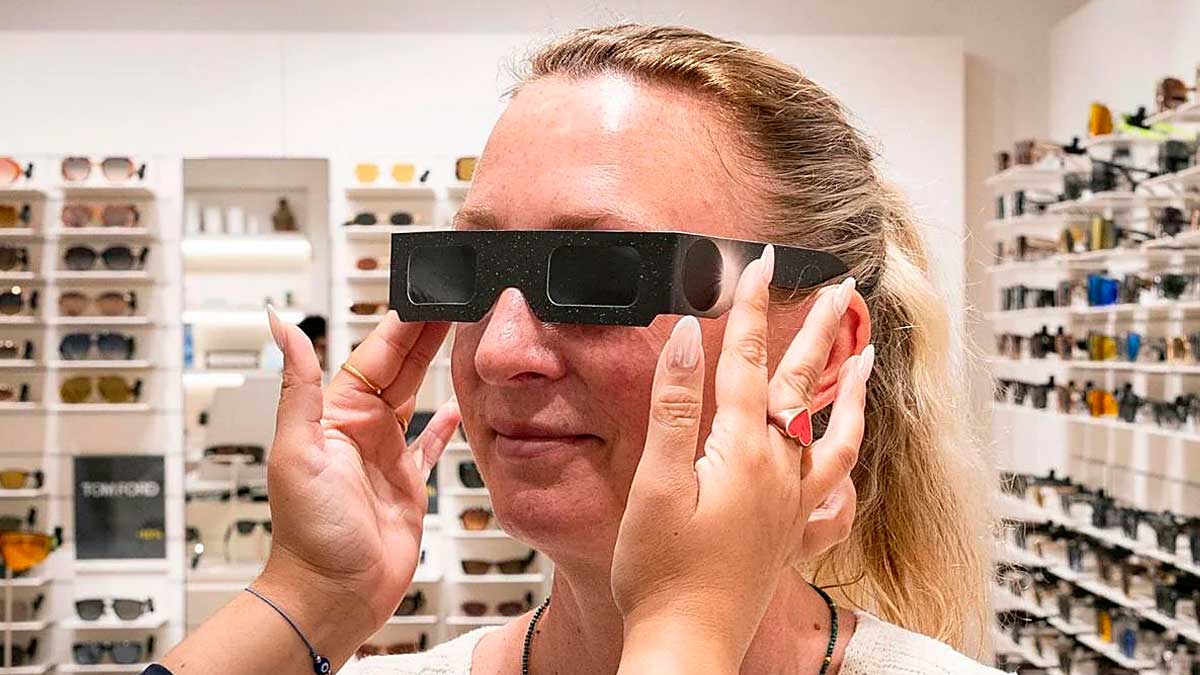 Mujer probando gafas especiales para eclipse solar en Andalucía