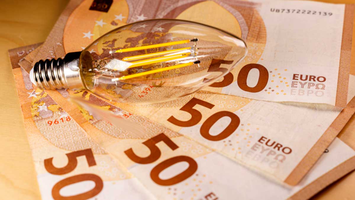 Bombilla sobre billetes de 50 euros simbolizando el aumento del precio de la luz en Andalucía