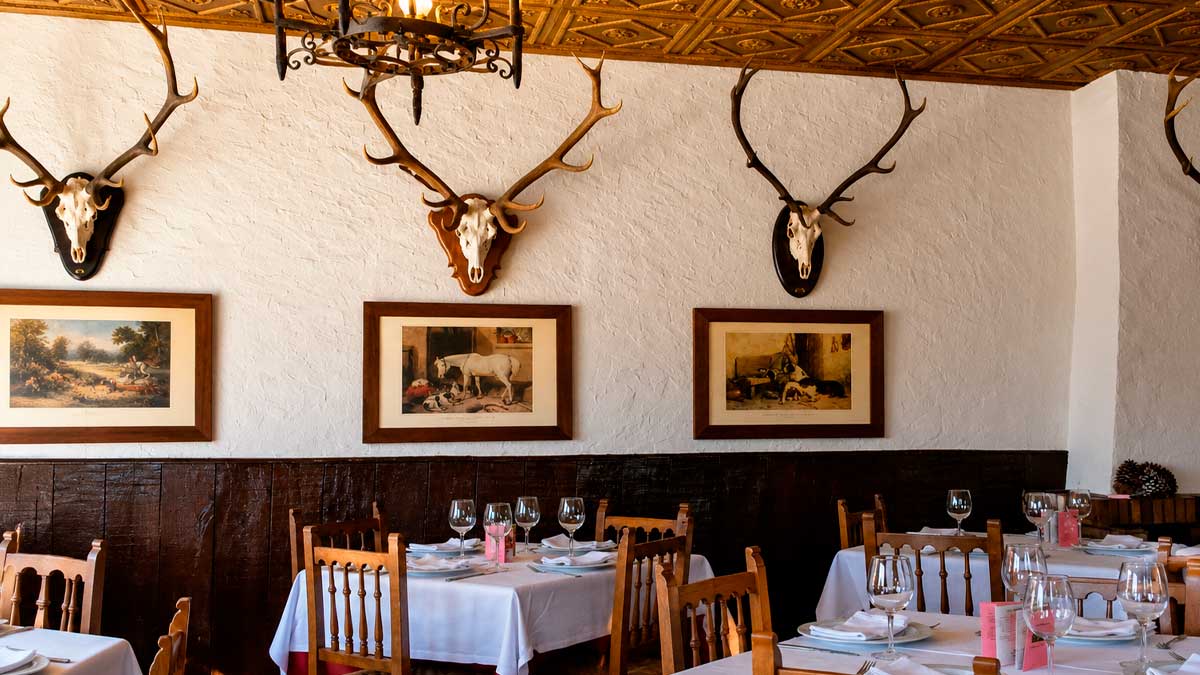 Restaurante en la A-4 Orellana Perdiz decorado con cabezas de ciervo y mesas preparadas