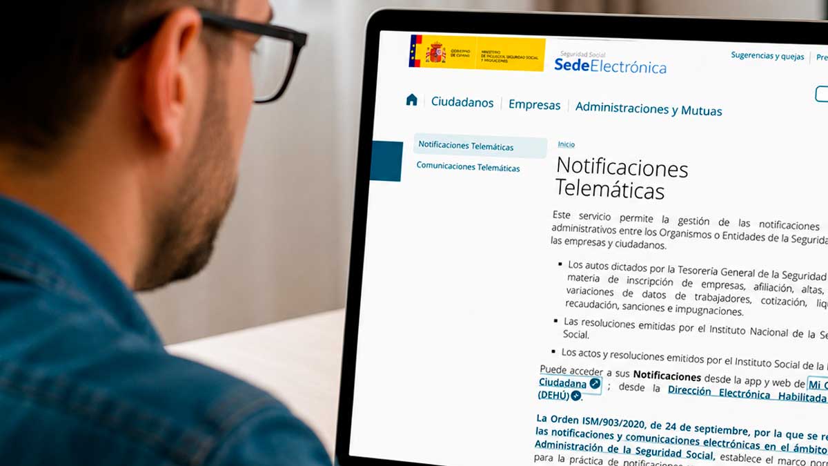 Persona consulta una notificación electrónica de la Seguridad Social durante una baja laboral.