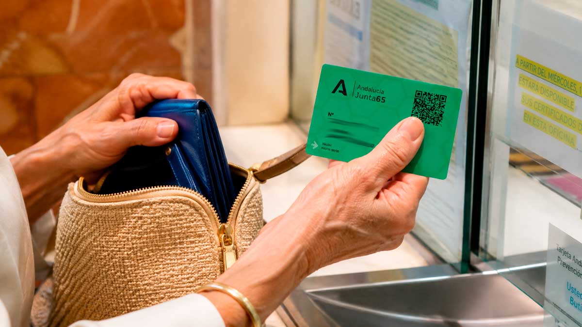 Persona mostrando la tarjeta Andalucía Junta 65 en una ventanilla