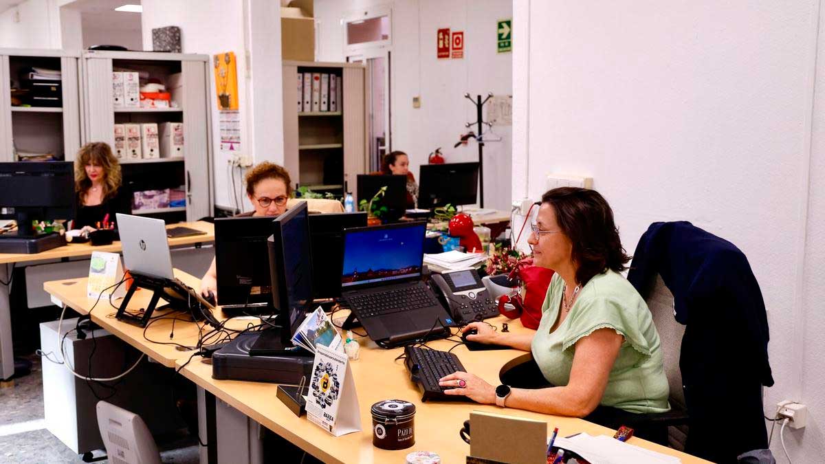 Empleados de la Junta trabajando en oficina con ordenadores, teletrabajo y control horario digital