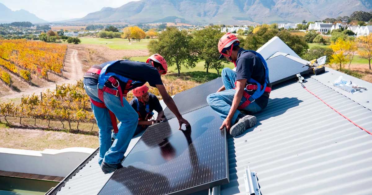 Instaladores colocando placas solares en una vivienda en Andalucía