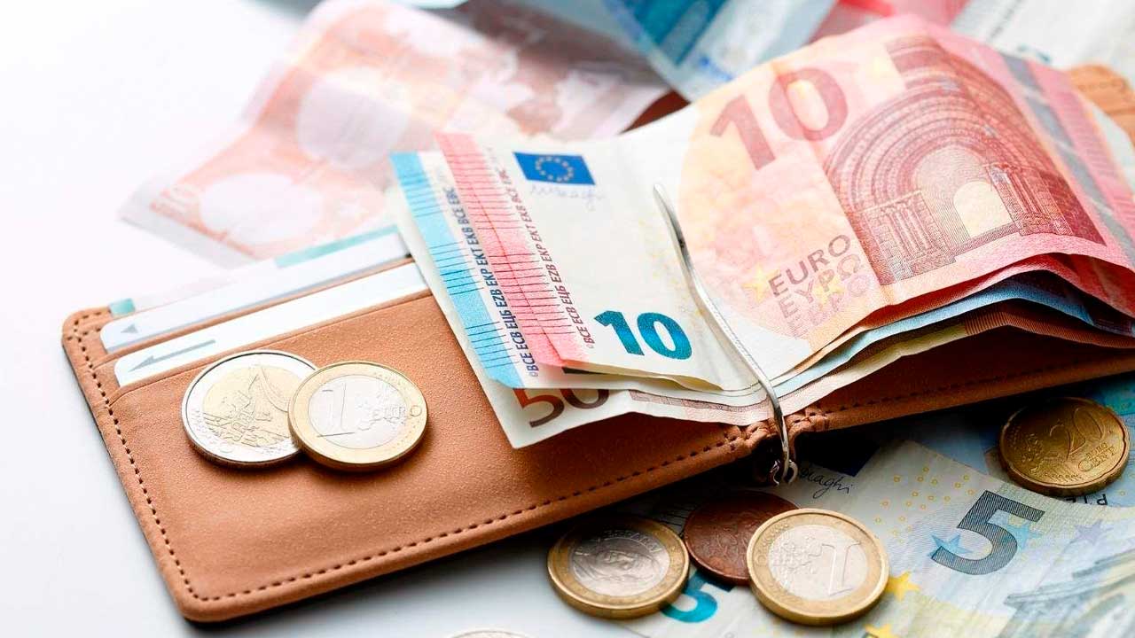 Billetes y monedas de euro en una cartera para ilustrar los límites de los pagos en efectivo en España