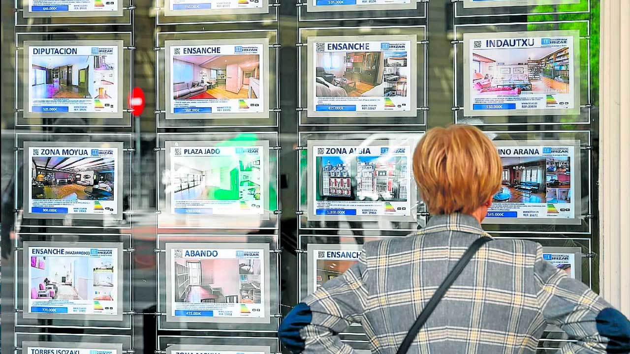 Persona consulta ofertas de viviendas en una inmobiliaria