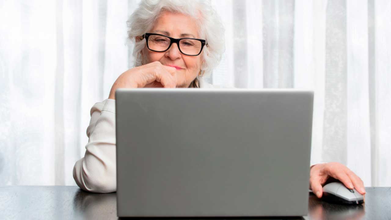 Mujer consulta en un ordenador información sobre su jubilación anticipada