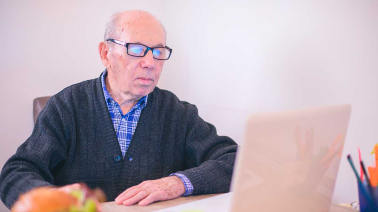 Hombre próximo a la jubilación usando un ordenador para realizar un trámite de empleo