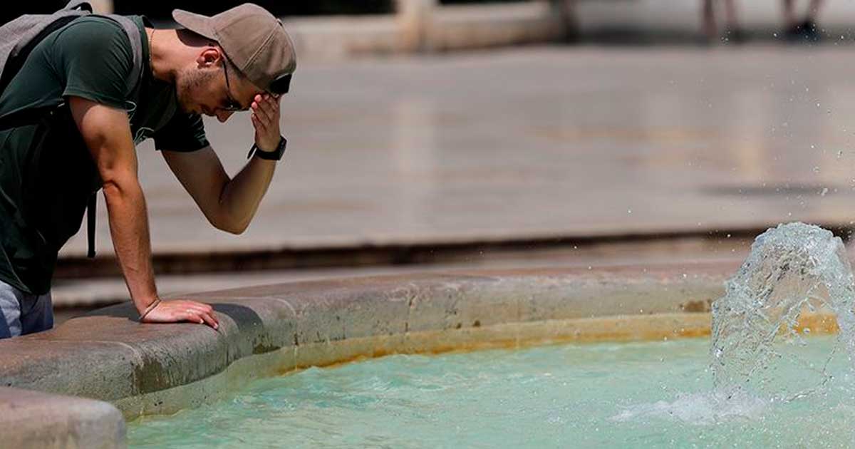 Un hombre se refresca en una fuente durante una jornada de calor en Andalucía