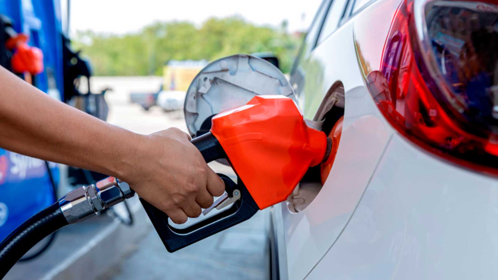 Conductor repostando gasolina en una estación de servicio