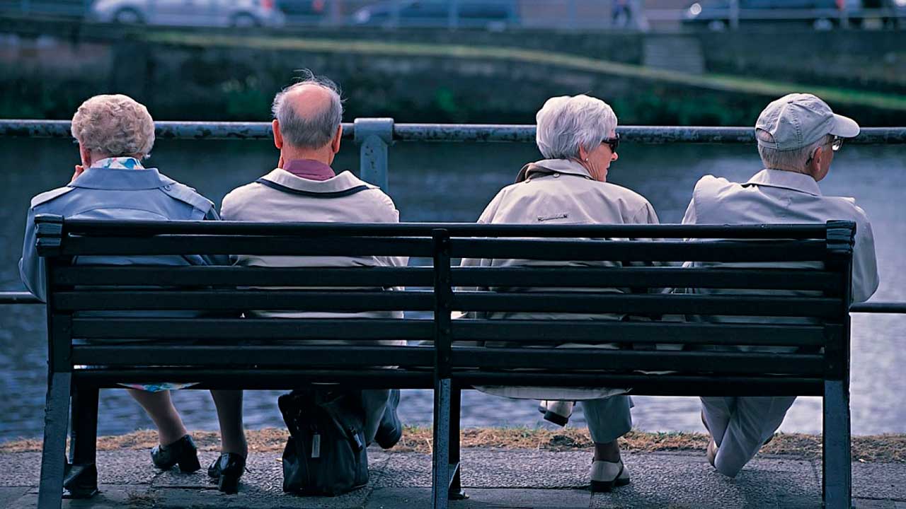 Pensionistas sentados en un banco ante la posible subida de las pensiones en 2027
