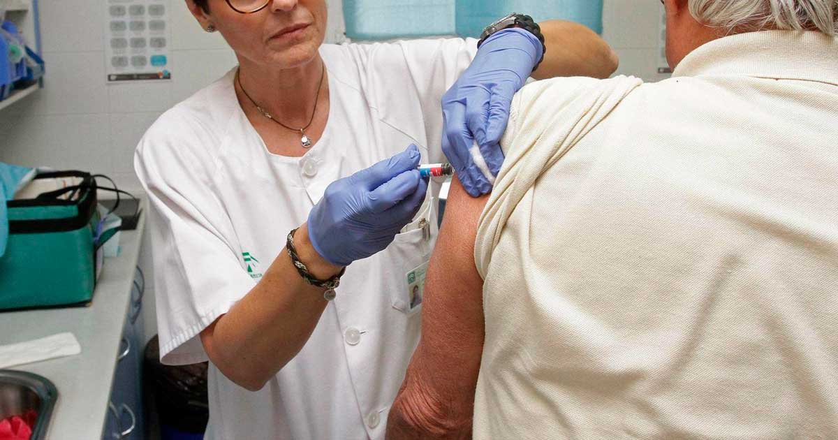 Profesional sanitaria vacuna contra la gripe a una persona mayor en Andalucía