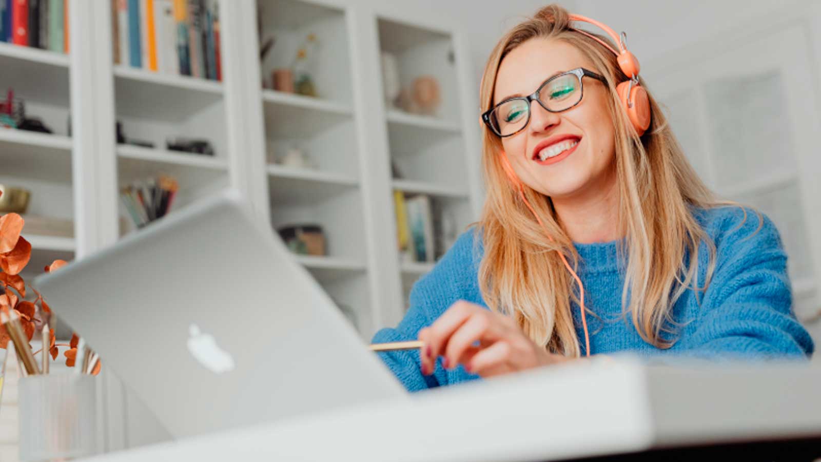 Mujer con auriculares realizando un curso online desde su ordenador portátil