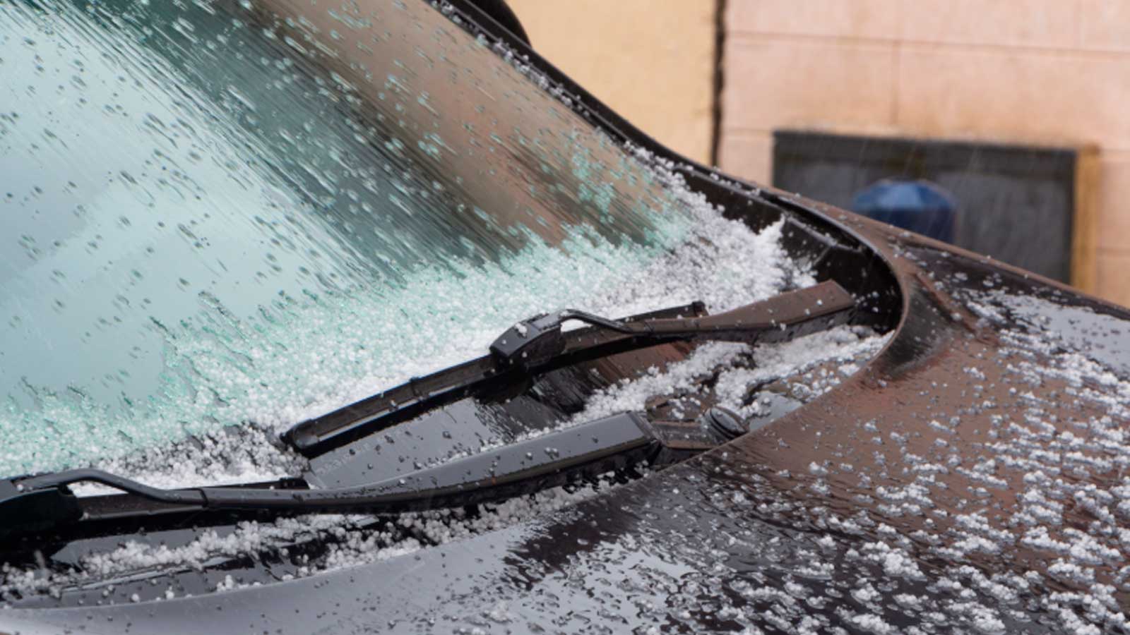 Granizo acumulado sobre el parabrisas de un coche durante una tormenta