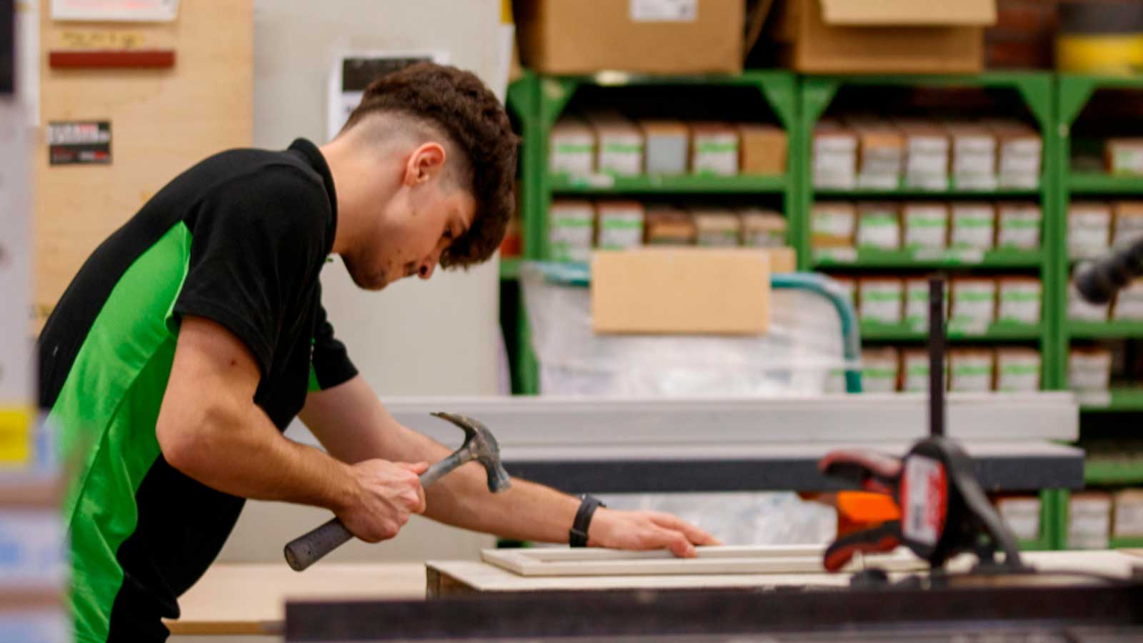 Joven realizando trabajos de carpintería en un taller, una actividad relacionada con la formación profesional y el empleo juvenil.