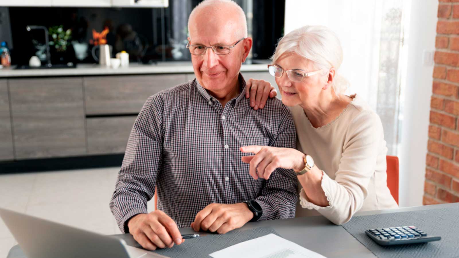 Pareja de pensionistas consultando sus cuentas ante la previsión de subida de las pensiones en 2027