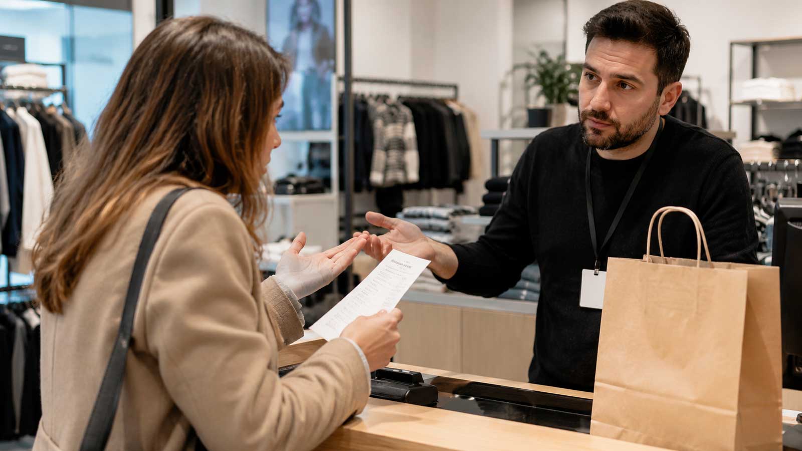 Una clienta reclama la devolución del dinero a un dependiente en una tienda de ropa de Andalucía.