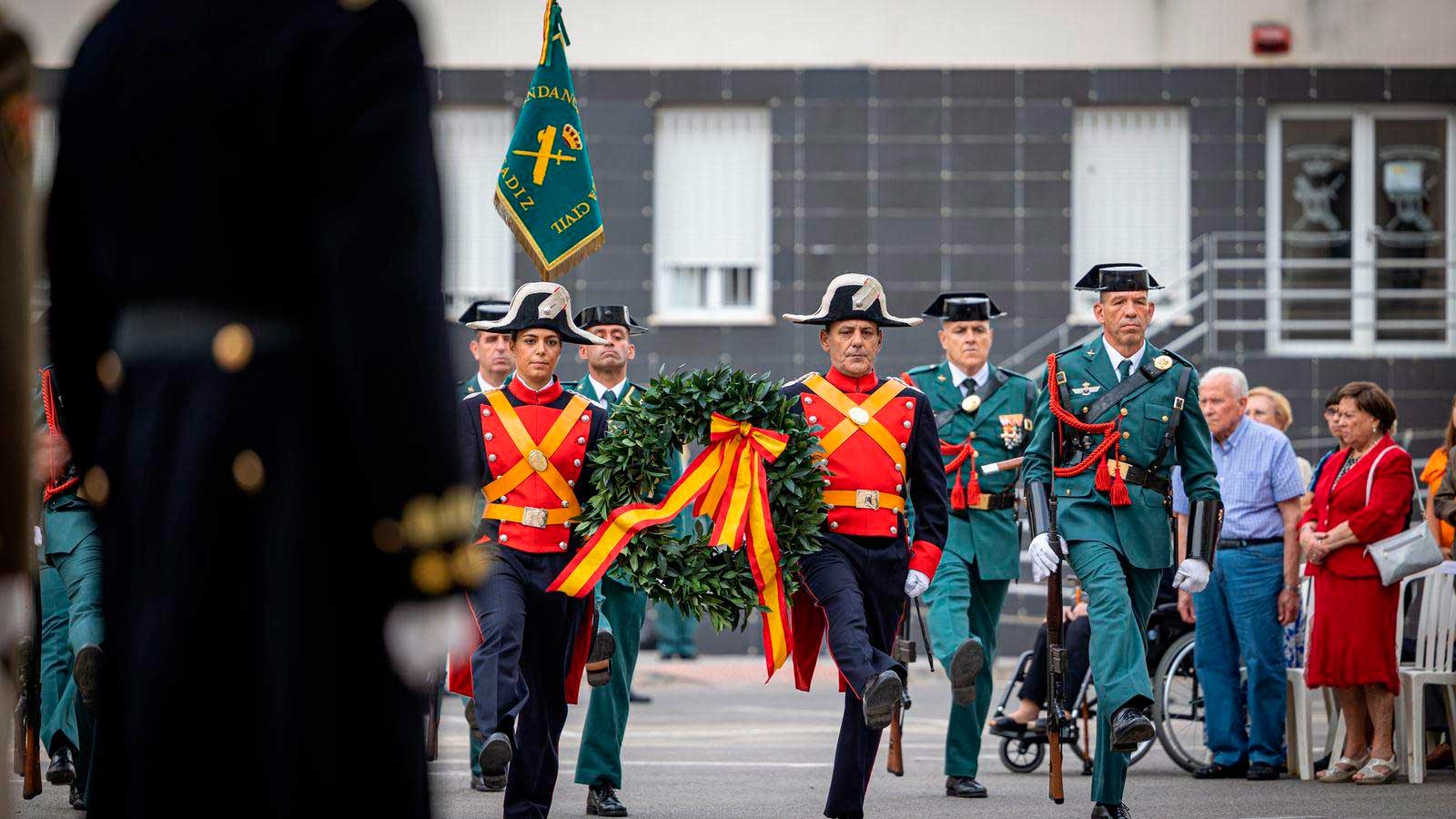 Guardias civiles desfilan con una corona de laurel durante un acto institucional relacionado con la Virgen del Pilar.